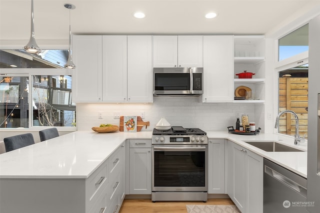 kitchen featuring appliances with stainless steel finishes, white cabinetry, a healthy amount of sunlight, and sink