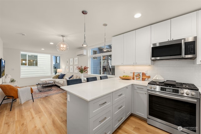 kitchen featuring kitchen peninsula, stainless steel appliances, and white cabinets