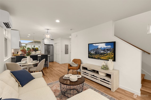 living room featuring light wood-type flooring, electric panel, and a wall mounted AC