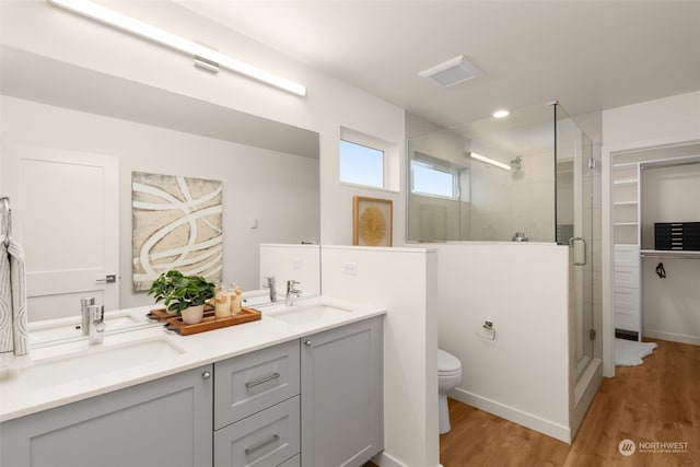 bathroom with hardwood / wood-style floors, vanity, toilet, and an enclosed shower