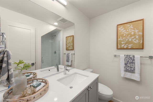 bathroom with vanity, toilet, and a shower with shower door