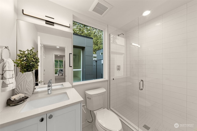 bathroom featuring vanity, toilet, and a shower with shower door