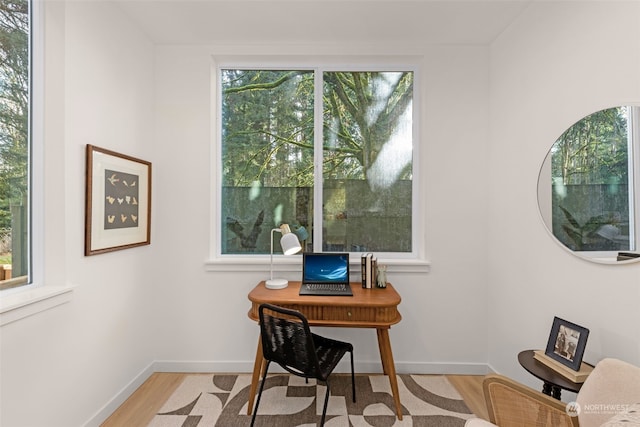 office space featuring light wood-type flooring and a healthy amount of sunlight