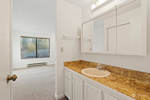 bathroom with a baseboard radiator, baseboards, a textured ceiling, and vanity