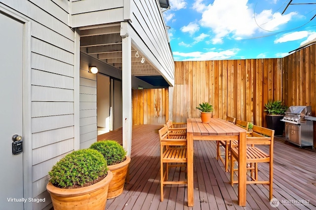 wooden terrace with outdoor dining space and grilling area