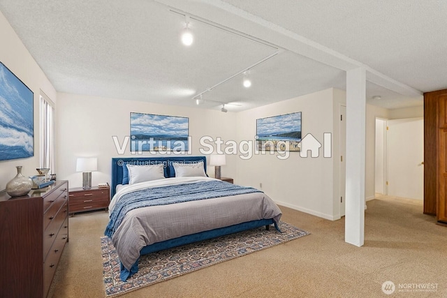 bedroom featuring a textured ceiling, baseboards, and light colored carpet