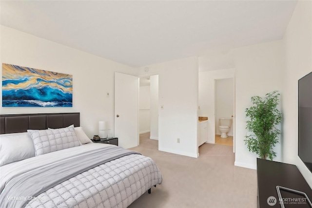 bedroom featuring baseboards, ensuite bath, and light colored carpet