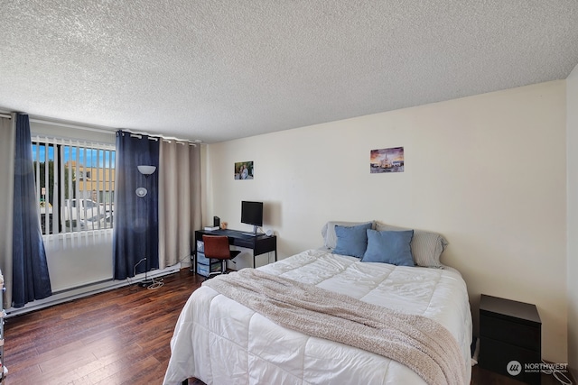 bedroom with a textured ceiling and dark wood-type flooring