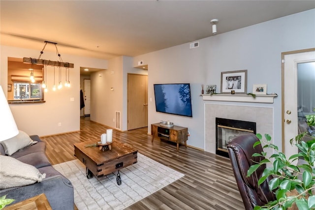 living room with wood-type flooring, sink, and a tile fireplace