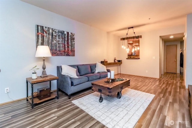 living room with wood-type flooring and an inviting chandelier