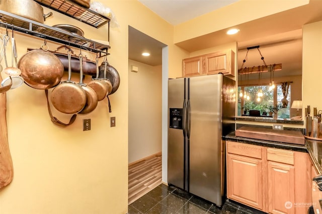 kitchen with stainless steel fridge with ice dispenser, hanging light fixtures, and light brown cabinetry