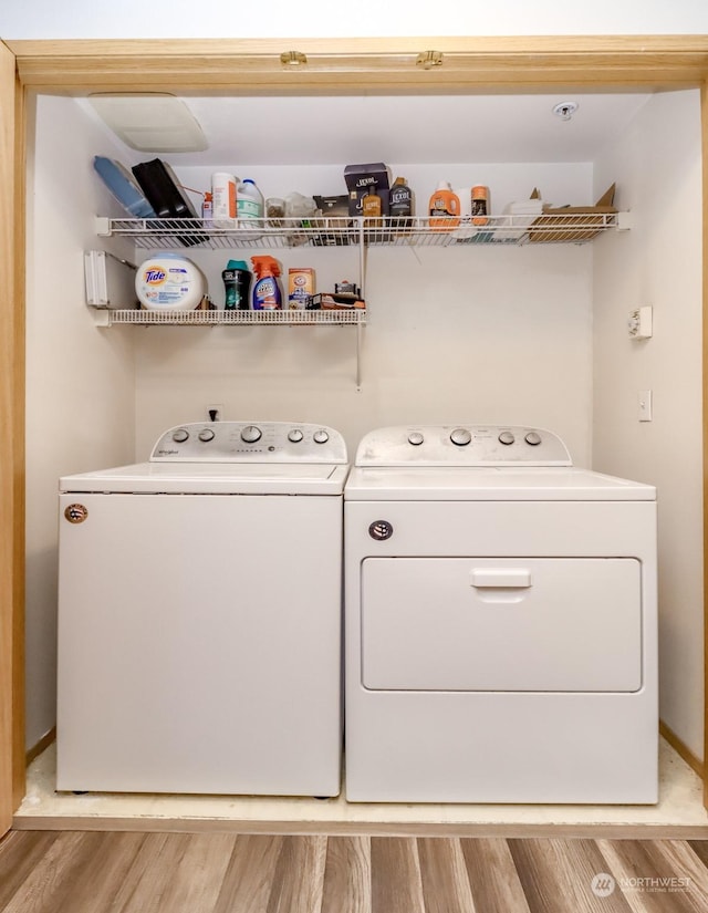 washroom featuring washing machine and dryer and light hardwood / wood-style floors