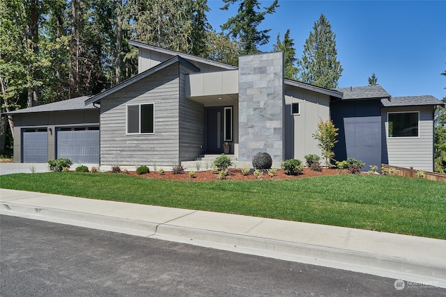 contemporary home featuring a front yard and a garage