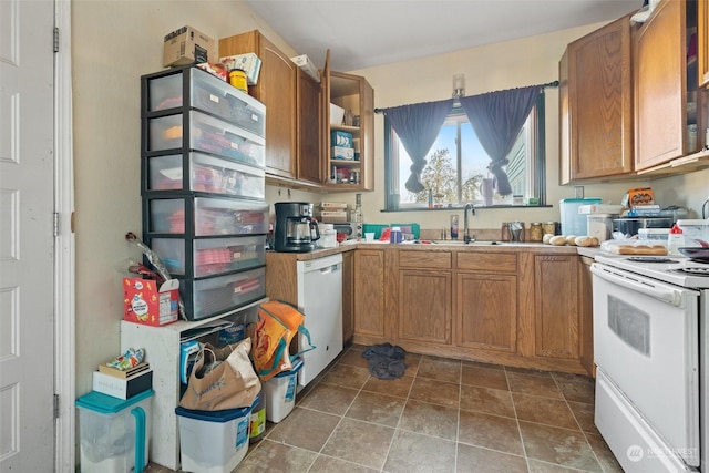 kitchen featuring white appliances, dark tile patterned flooring, and sink