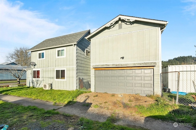 view of front of property featuring ac unit and a garage