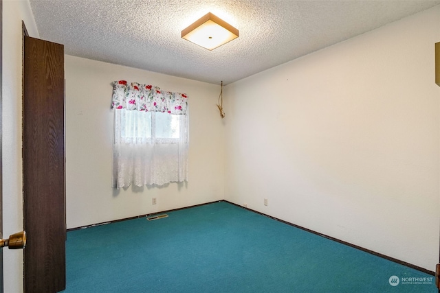 unfurnished room featuring carpet flooring and a textured ceiling