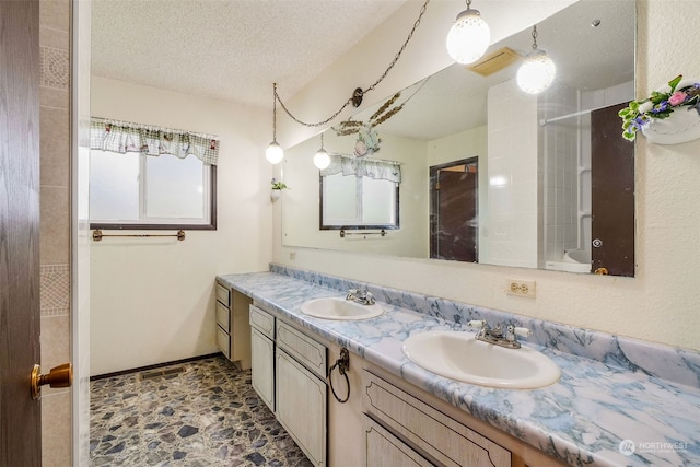 bathroom with vanity, shower / bathtub combination, and a textured ceiling