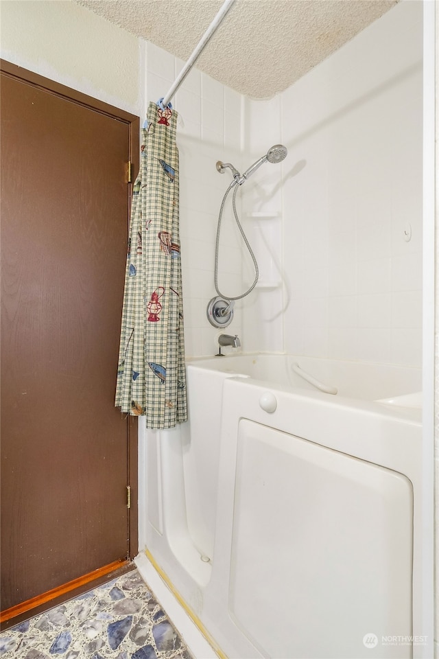 bathroom featuring shower / tub combo with curtain and a textured ceiling