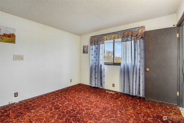 empty room featuring carpet floors and a textured ceiling