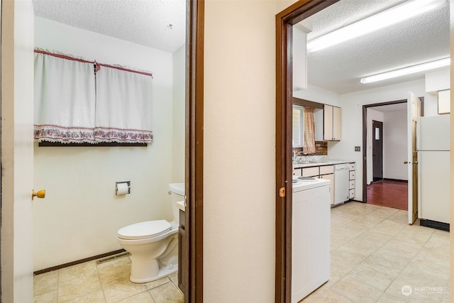 bathroom with vanity, toilet, and a textured ceiling