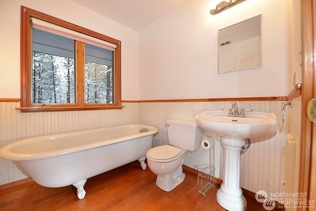 bathroom featuring toilet, sink, a washtub, and hardwood / wood-style flooring