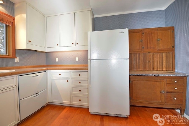 kitchen with white cabinetry, light hardwood / wood-style floors, white appliances, ornamental molding, and sink