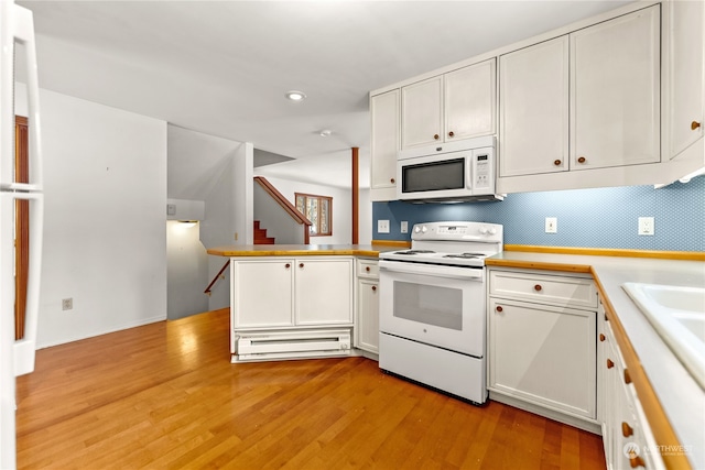 kitchen with white cabinetry, white appliances, and kitchen peninsula