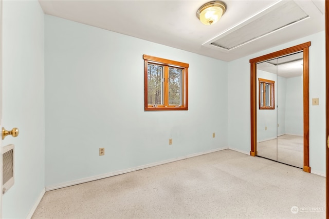 unfurnished bedroom featuring heating unit and a closet