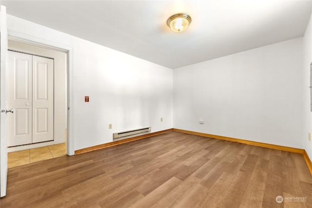 spare room featuring hardwood / wood-style flooring and a baseboard radiator