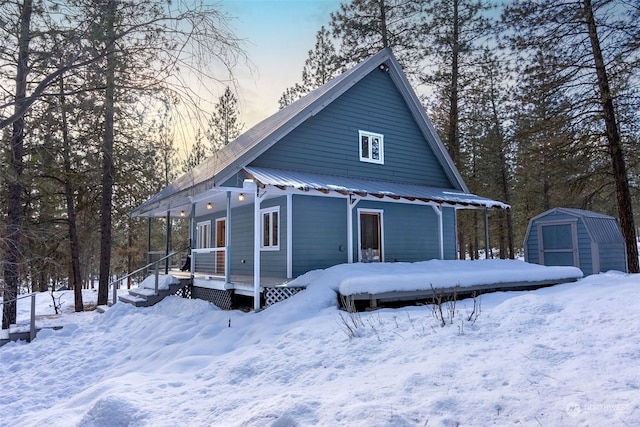 exterior space with a porch and a storage shed