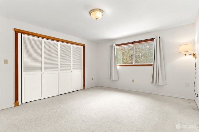 unfurnished bedroom with light colored carpet and a closet