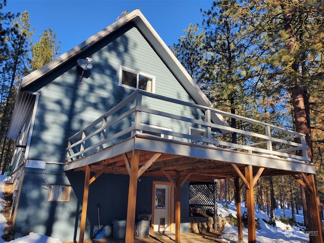 snow covered property with a wooden deck