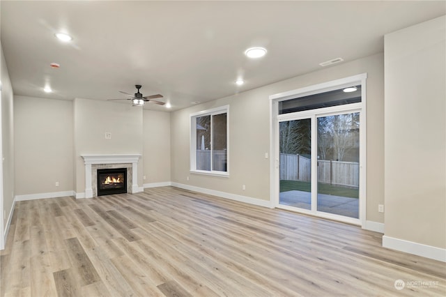 unfurnished living room featuring ceiling fan and light hardwood / wood-style floors