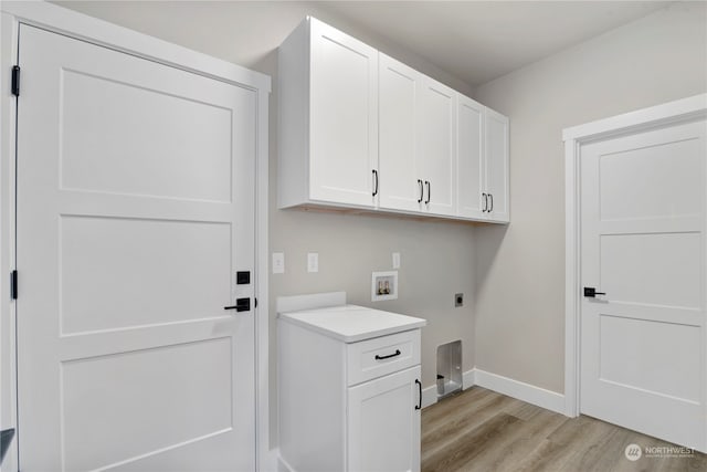 washroom featuring electric dryer hookup, hookup for a washing machine, cabinets, and light wood-type flooring