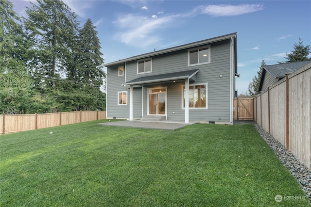 rear view of house with a yard and a patio