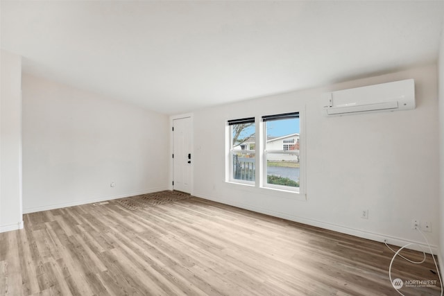 spare room featuring light hardwood / wood-style flooring and a wall mounted AC