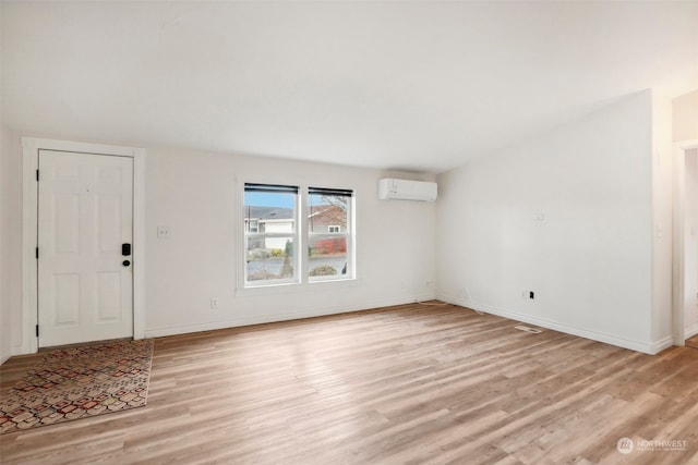 interior space featuring an AC wall unit and light hardwood / wood-style flooring