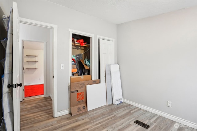 bedroom with hardwood / wood-style flooring, a textured ceiling, and a closet