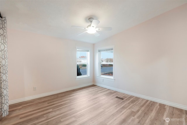 empty room with vaulted ceiling, light hardwood / wood-style flooring, and ceiling fan