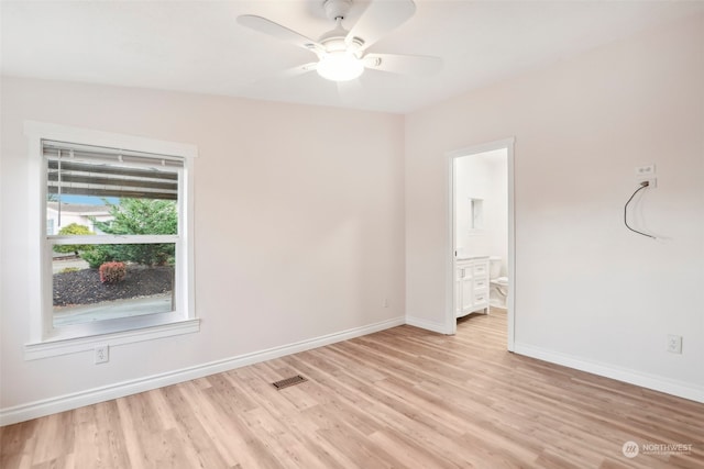 empty room with ceiling fan, light wood-type flooring, and vaulted ceiling