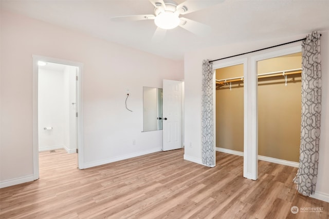 unfurnished bedroom with ceiling fan, light wood-type flooring, and two closets