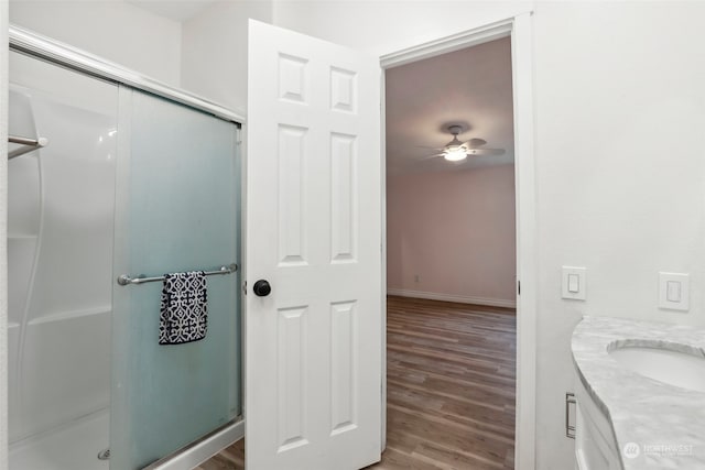 bathroom featuring ceiling fan, hardwood / wood-style floors, vanity, and an enclosed shower