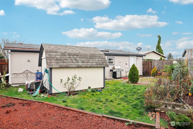 rear view of property with a yard and a shed