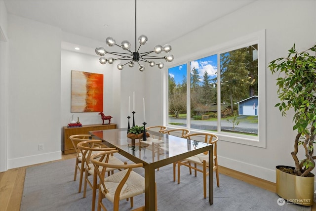 dining room with light hardwood / wood-style floors and an inviting chandelier