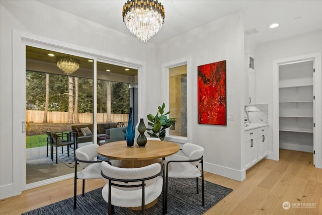 dining area featuring light hardwood / wood-style floors and an inviting chandelier