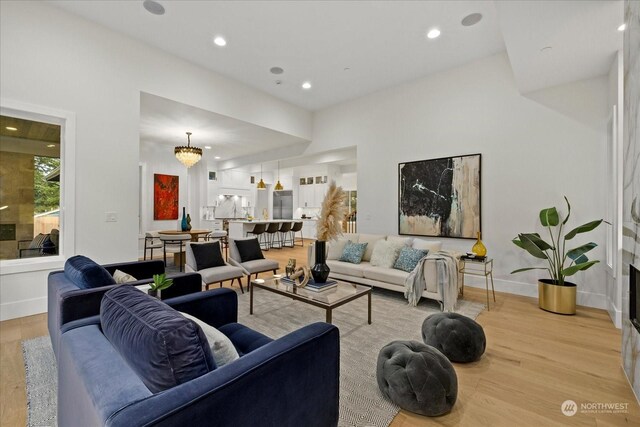 living room featuring a chandelier and light wood-type flooring