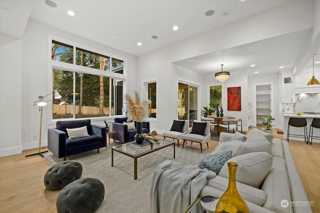 living room featuring a chandelier and light wood-type flooring