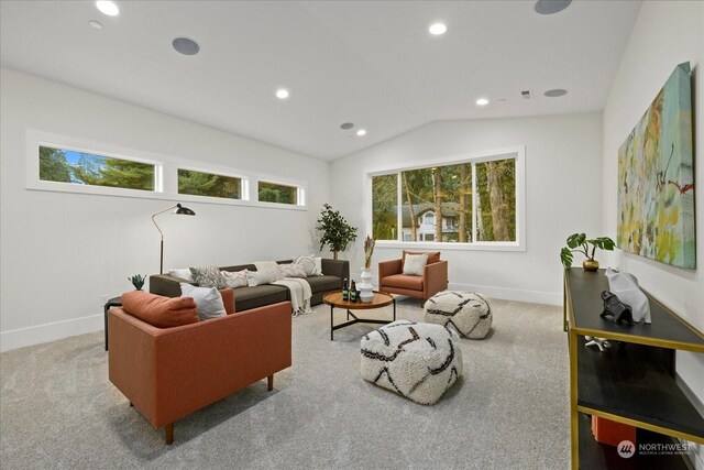 living room featuring light colored carpet and vaulted ceiling