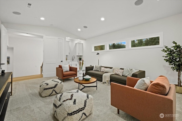 living room with sink, lofted ceiling, and light hardwood / wood-style flooring