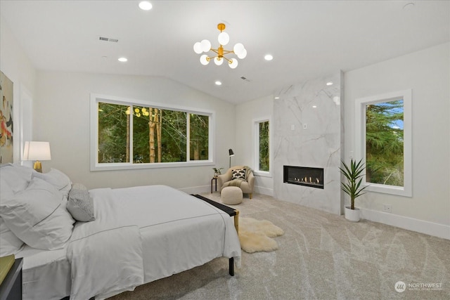 bedroom with carpet flooring, multiple windows, a premium fireplace, and vaulted ceiling